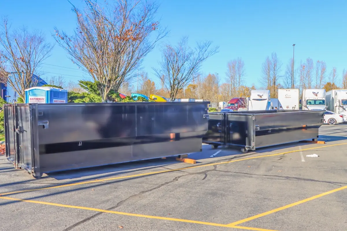 Professional dumpster rental service with roll-off container on residential driveway in Yukon